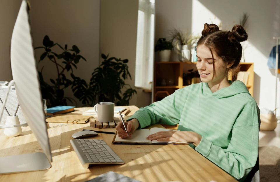person writing in notebook during morning planning session to build a daily anti-procrastination framework