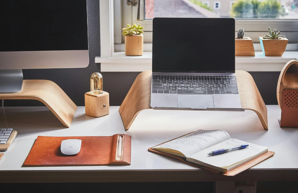 clean minimal desk setup with laptop and notebook to reduce friction and beat procrastination