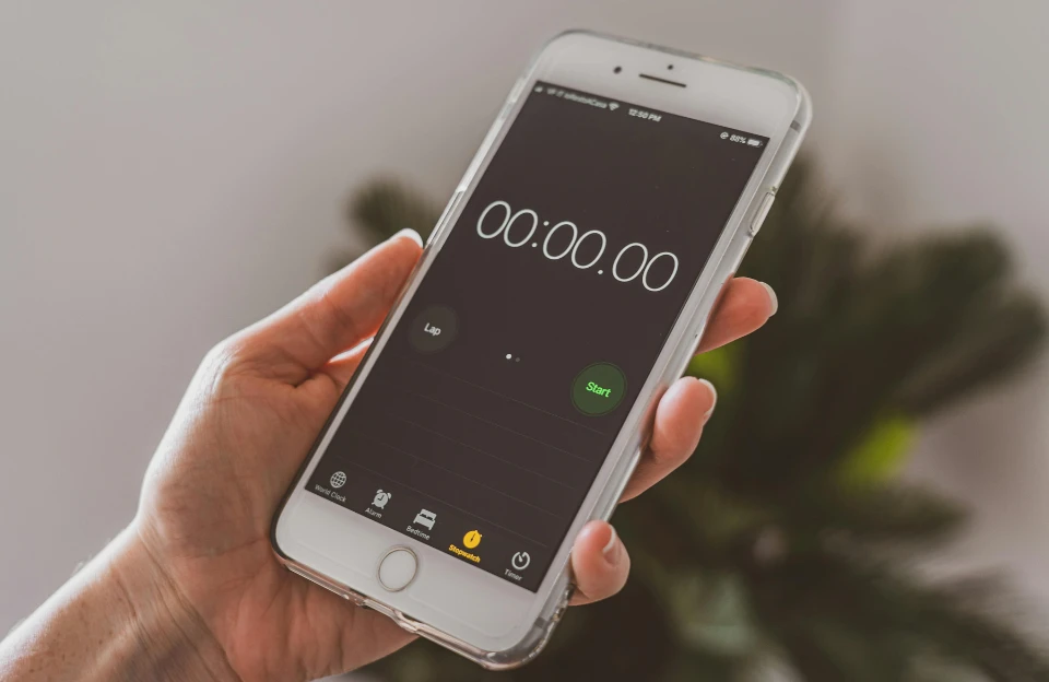 hand setting a two-minute timer on phone to use the two-minute rule against procrastination