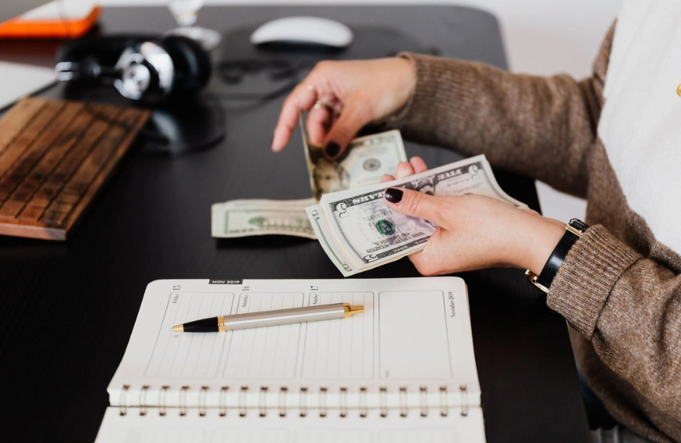 pay-yourself-first-savings-automatic-transfer Clean desk with notebook and savings planner representing the pay yourself first money habit