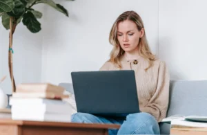 Person starting a side hustle from their couch at night using a laptop